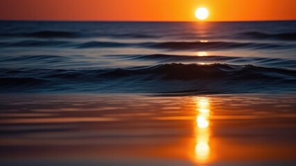 Golden sunset sky reflecting in the water, close-up view from the shore. Setting sun. Waves texture. relax and resort