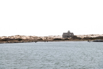 View of Oregon Inlet Life Saving Station from Bonner Bridge Pier against a white sky