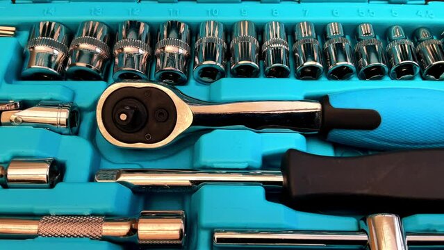 Closeup push-in shot of a small chrome plated steel, numbered drive socket and screwdriver bit set, with ratchet wrench handle and extension bars, in a storage case.