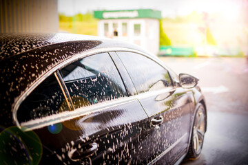White foam is applied to the car body at the car wash