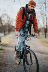 A young, casually dressed man finds joy while cycling on a pathway in a serene park setting.