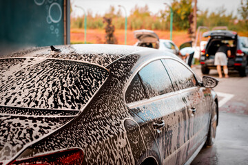 White foam is applied to the car body at the car wash