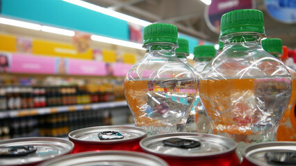 Close-up of many sweet soda bottles in a supermarket