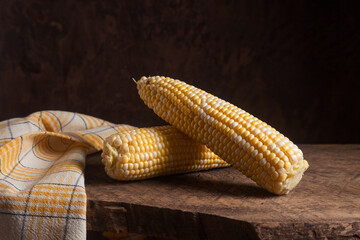 Two cobs sweet corn on wooden background..