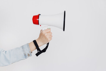 Woman hand holds magaphone or loud speaker over white background