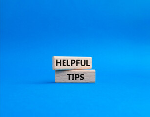 Helpful tips symbol. Wooden blocks with words Helpful tips. Beautiful blue background. Business and Helpful tips concept. Copy space.