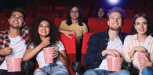 Friends with popcorn watching movie in cinema