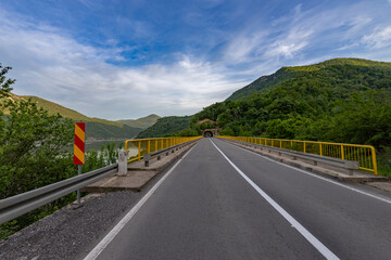  The road is devoid of vehicles, emphasizing the tranquility of the scene. The perspective draws the viewer's eye towards the tunnel, inviting thoughts of the journey that lies ahead.