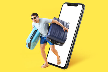 Male tourist with suitcases on yellow background