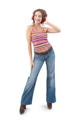 Joyful young woman who is listening to music through red headphones, dancing and looks to the side with her blue eyes while being isolated against a white background