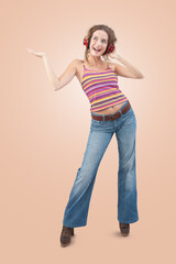 Joyful young woman who is listening to music through red headphones, dancing and looks to the side...