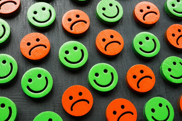 Happy and sad emoticons as a symbol of mood, psychology and well-being.