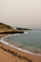 Views of Waves Approaching the Cliffside on a Hazy Day in Albufeira Portugal