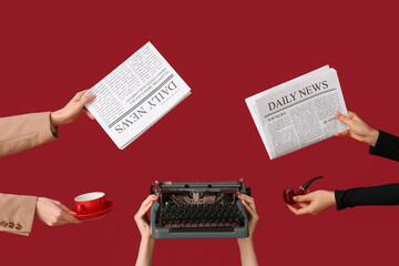 Female hands holding newspapers with vintage typewriter, cup of coffee and smoking pipe on red...