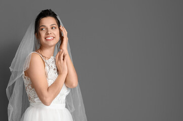 Fototapeta na wymiar Young bride in wedding dress on dark background