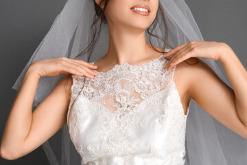 Beautiful young bride in wedding dress on dark background, closeup