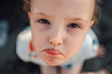 Close up of a sad child on a beach.