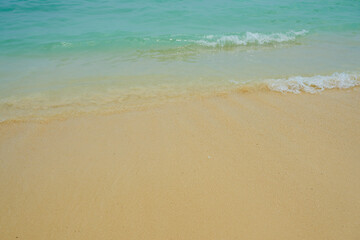 Waves and foam on a tropical sandy beach.
