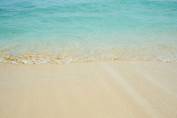 Waves and foam on a tropical sandy beach.