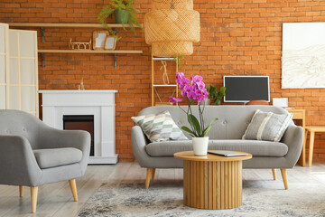 Fototapeta premium Interior of living room with sofa, armchair and orchid flower on table
