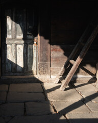 Old wooden door with a wooden stare in a light ray