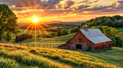 The sun is setting over farm with barn in the foreground.