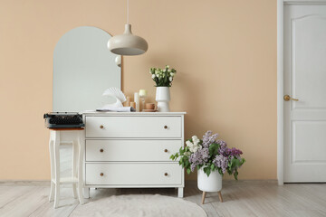 Interior of room with drawers, mirror and vintage typewriter on table