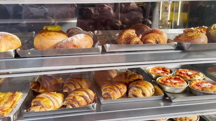 A bakery display case filled with an assortment of fresh, golden-baked goods.