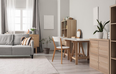Interior of modern living room with grey sofa and workplace