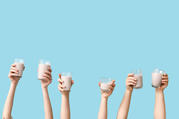Female hands with glasses of sweet chocolate milk on blue background - Powered by Adobe