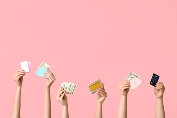 Female hands with credit cards, money and wallet on pink background
