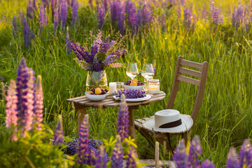 Private wedding party for two, table set with floral decor and greenery, fruits, wine in lupine...