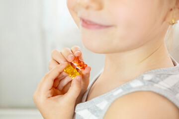 close-up preschool child, girl 5 years old wants eat gelatinous sweets, gummy bear, kid has good...