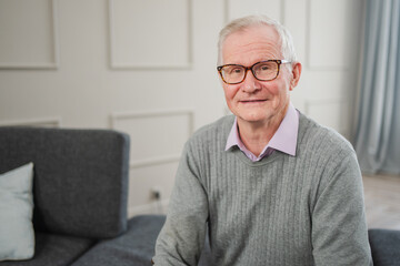 Portrait of confident stylish European middle aged senior man at home. Older mature 70s man smiling. Happy attractive senior grandfather looking camera close up face headshot portrait. Happy people