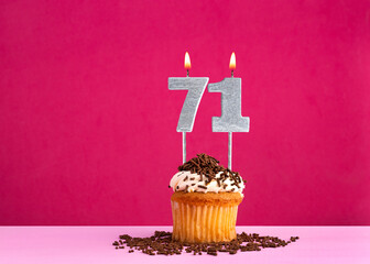 Birthday celebration with candle number 71 - Chocolate cupcake on pink background
