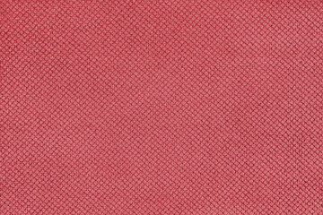 Plain red velor upholstery fabric, jacquard with fine diamond texture background. Close up, macro cloth textile surface. Wallpaper, backdrop with copy space