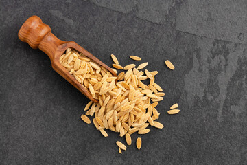 Risoni, organic pasta on spoon - Raw dried orzo