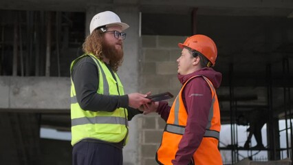 Conflict construction engineers having a meeting at building site, male people pushing and swearing standing in hardhat or safety wear. 