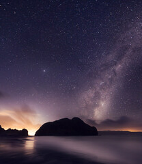 piha lion rock with milky way stars and a high tide 