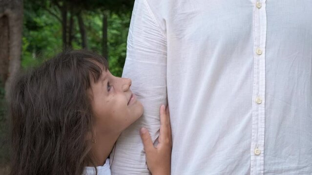 Daughter and dad time together in spring wood. A little daughter with smile hold dd hand and relax in the summer forest.