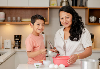 Hispanic mom and son preparing a cake at home - family time - single mother with her son