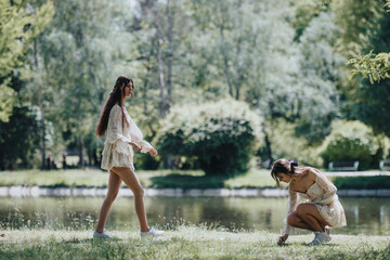 Two young women stroll and explore in a sunny, lush park, embodying carefree joy and the beauty of...