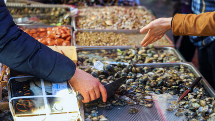 Fisherman selling Clams and mussels at a Seafood Market in Italy