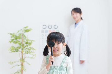 眼科で視力検査する子供