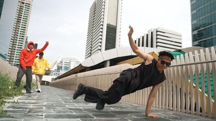 Panorama shot of break dancer perform b-boy performance and energetic footstep at city view. Break...