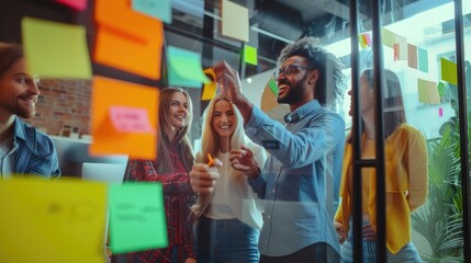 A diverse team of professionals joyfully collaborates using sticky notes on a glass wall in a vibrant, modern office. AIG41