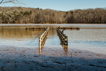 A flooded lake with pier underwater and debris floating on surface