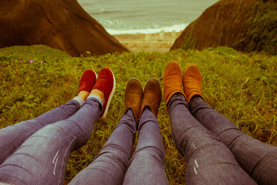 pies de mujeres amigas en acantilado de primavera