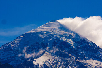 Lanin volcano surrounded by clouds, clear summit in sight and ice glaciers, between Argentina and Chile, Lanin National Park