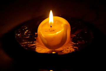 Burning candle isolated in selective focus